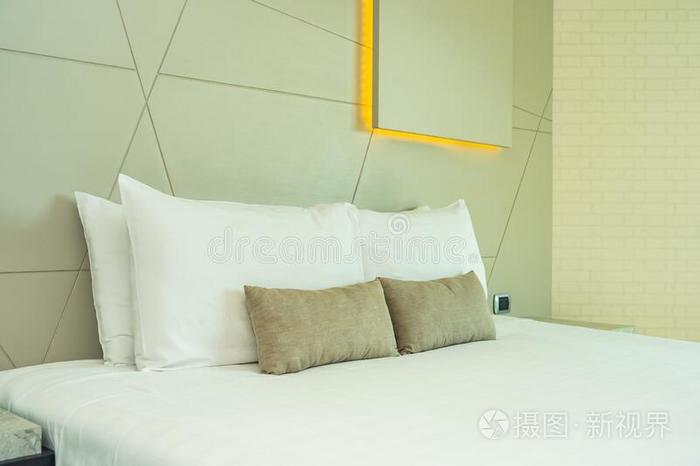 白色的舒适的枕头向床decorati向内部