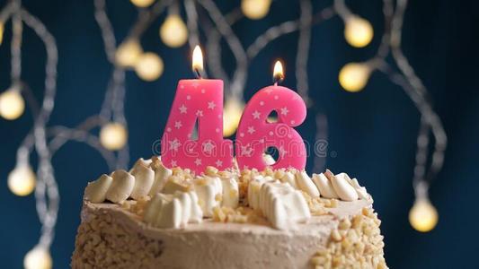 德巴克生日蛋糕和46数字粉红色的蜡烛向蓝色巴克格雷德照片