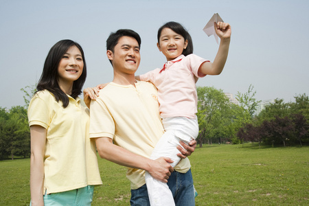 抱着孩子一家三口休闲生活照片
