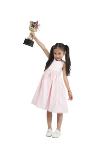 棚拍穿裙子的小女孩拿着奖杯