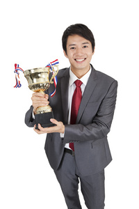 优胜者表达庆祝胜利尖叫与大微笑和举手手里捧着金灿灿的奖杯手争夺