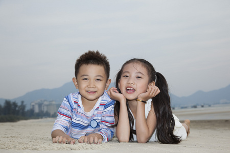 小男孩,小女孩在海滩玩耍照片