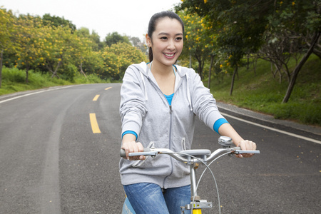 一个年轻女大学生在校园里骑车