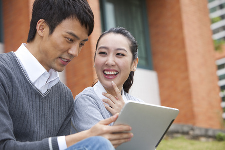 年轻大学生在校园里使用平板电脑