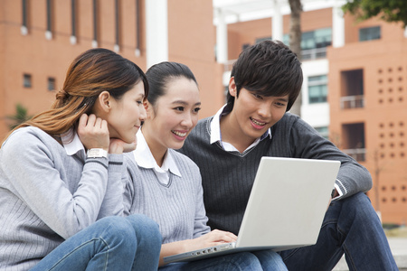 年轻大学生在校园里使用笔记本电脑照片