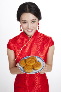 棚拍节日身穿红色旗袍的年轻女人端着月饼照片