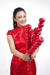 棚拍节日身穿红色旗袍的年轻女人拿着糖葫芦照片