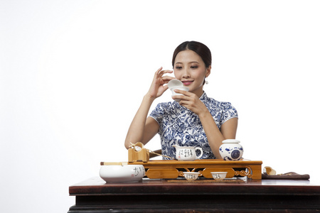 棚拍身穿旗袍的年轻女人喝茶照片