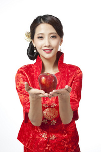 棚拍节日身穿红色旗袍的年轻女人和苹果