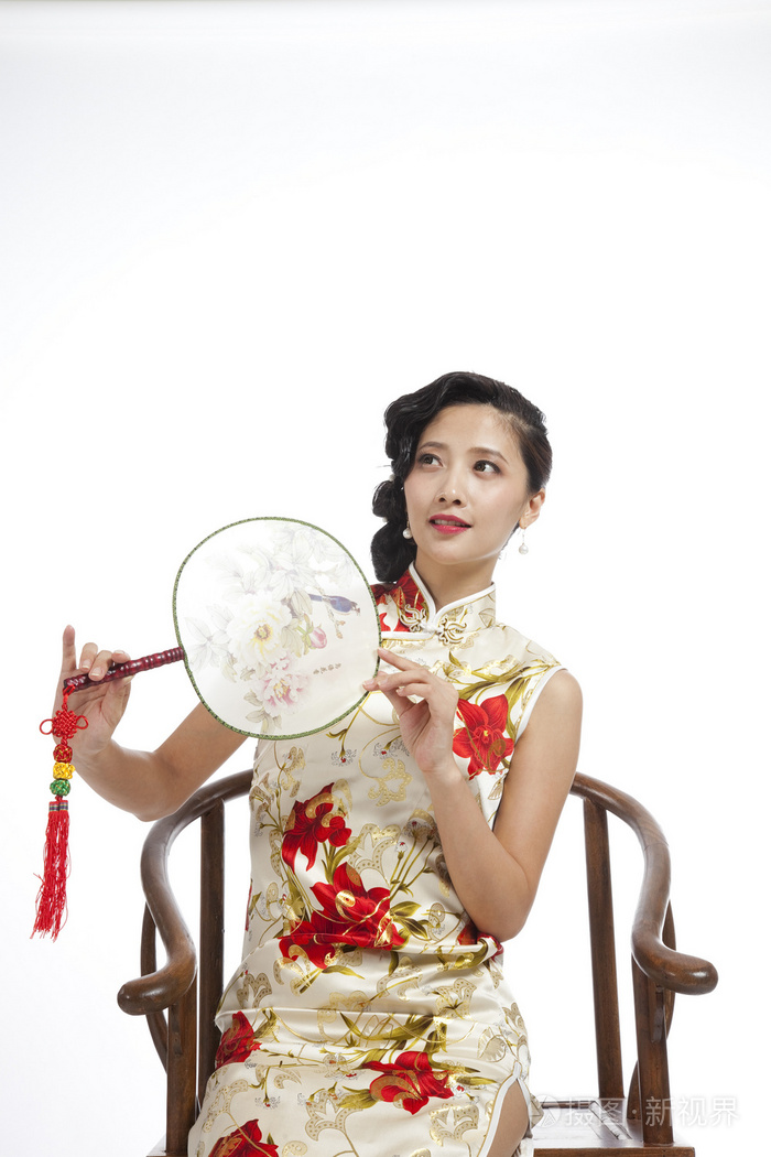 棚拍身穿旗袍的年轻女人拿着团扇