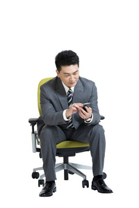 棚拍中年商务男士坐办公椅玩手机