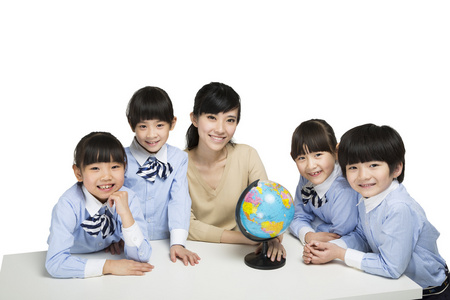 小学生和年轻女老师研究地球仪