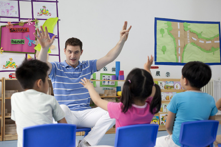 绿地小朋友幼儿园外教男老师给小朋友们上课照片