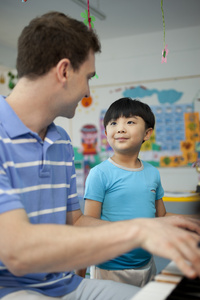 外教男老师和儿童弹钢琴