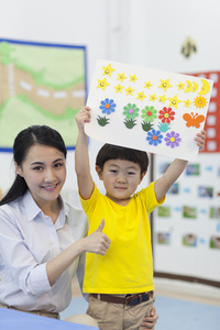 幼儿园女老师和儿童展示手工儿童画