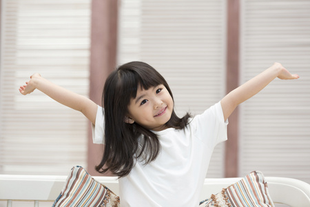 快乐的小女孩坐在沙发上照片