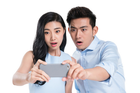 看手机惊讶年轻情侣一起玩手机照片