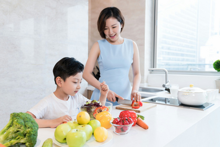 快乐的母子在厨房做饭照片