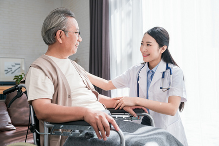 年轻的女医生在给老人做康复照片