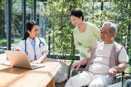 年轻女医生在给一对老夫妻检查身体照片