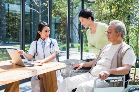年轻女医生在给一对老夫妻检查身体照片