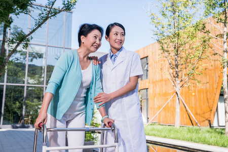 一个年轻女医生给一个老年人康复照片