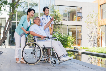 一个年轻女医生给一对老夫妻做康复照片