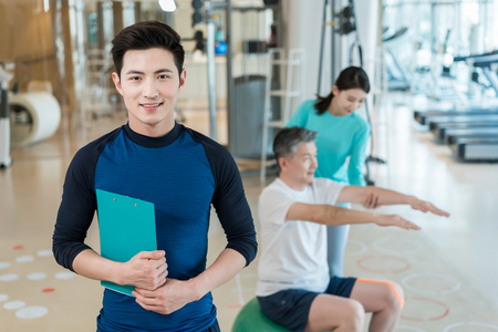 老年男性搞怪形象老年男子在私教的指导下健身照片