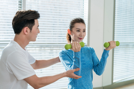 年轻女子在私教的指导下健身照片