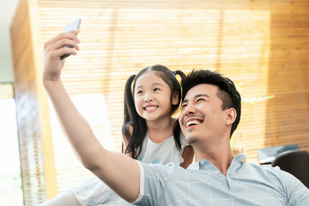十岁成长礼快乐的父女坐在沙发上自拍照片