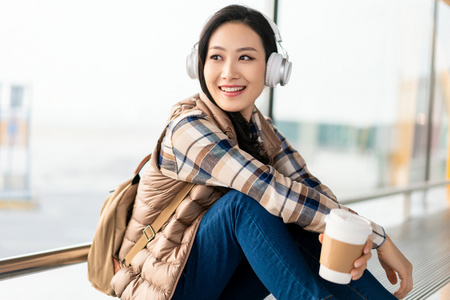 年轻女子在机场听音乐