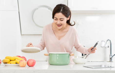 年轻女子在厨房做饭照片