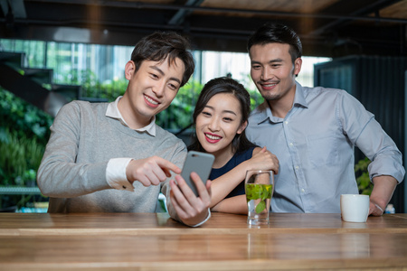快乐的朋友们聚会看手机照片