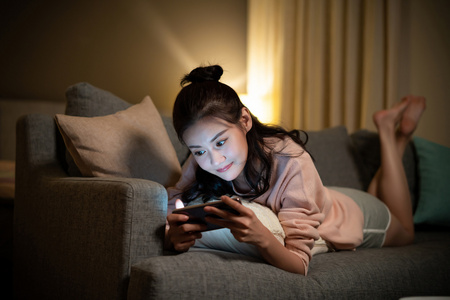 年轻女士在家玩手机游戏照片