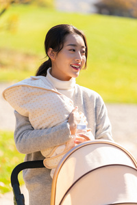 年轻的母亲抱着襁褓婴儿照片