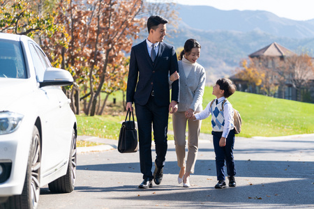 年轻夫妻送孩子去上学照片