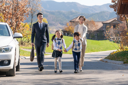 年轻夫妻送孩子去上学照片