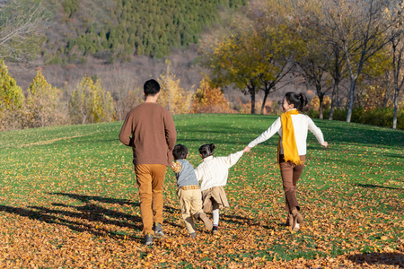 年轻夫妻带着孩子在公园玩耍照片