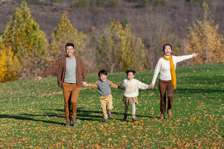年轻夫妻带着孩子在公园玩耍照片