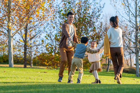 年轻夫妻带着孩子在公园玩耍照片