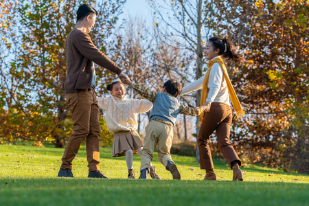 年轻夫妻带着孩子在公园玩耍照片
