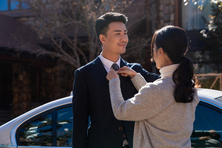 妻子为丈夫整理领带照片