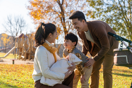 年轻家庭推着婴儿车散步