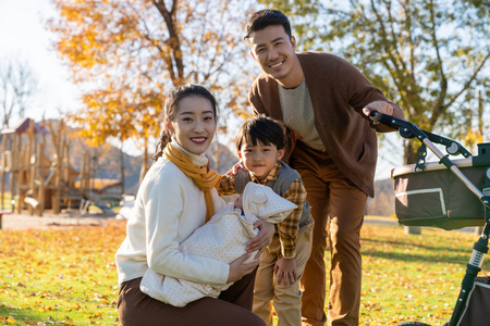 年轻家庭推着婴儿车散步