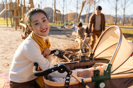 年轻家庭推着婴儿车散步