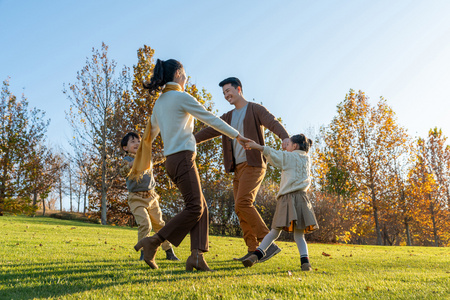 年轻夫妻带着孩子在公园玩耍照片
