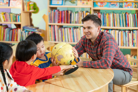 外籍老师教孩子辨认地球仪照片