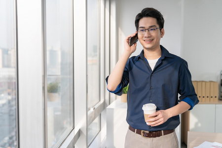 年轻商务男士在办公室打电话照片