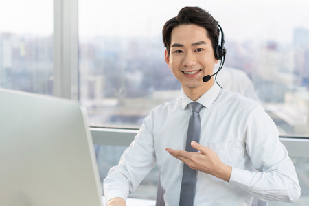 交谈男客服代表戴耳机呼叫中心代表微笑的客服代表年轻的客服代表快乐