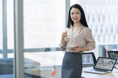 年轻商务女士在办公室喝咖啡照片